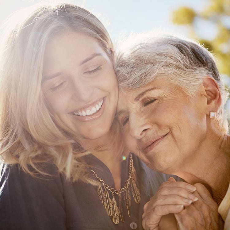 Older woman and younger woman embrace