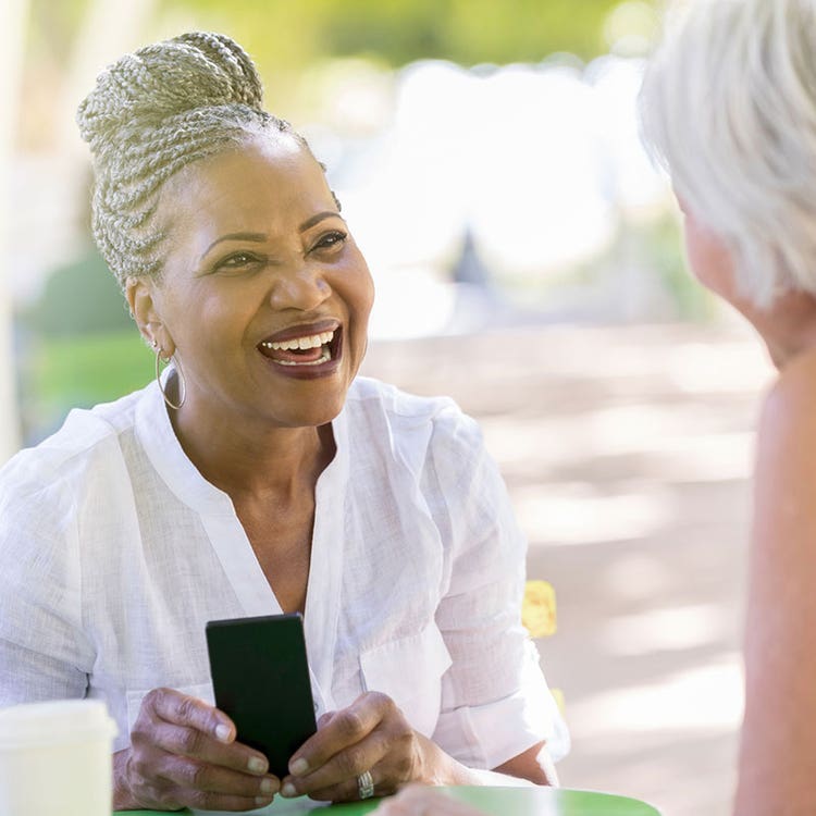 Older woman smiles at another older woman