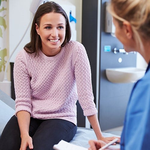 Woman talks to physician in doctor's office
