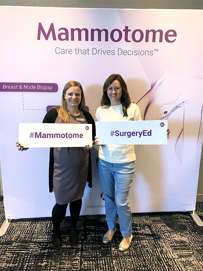 two women in front of Mammotome sign