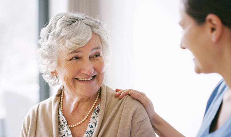 Older woman smiling at another person